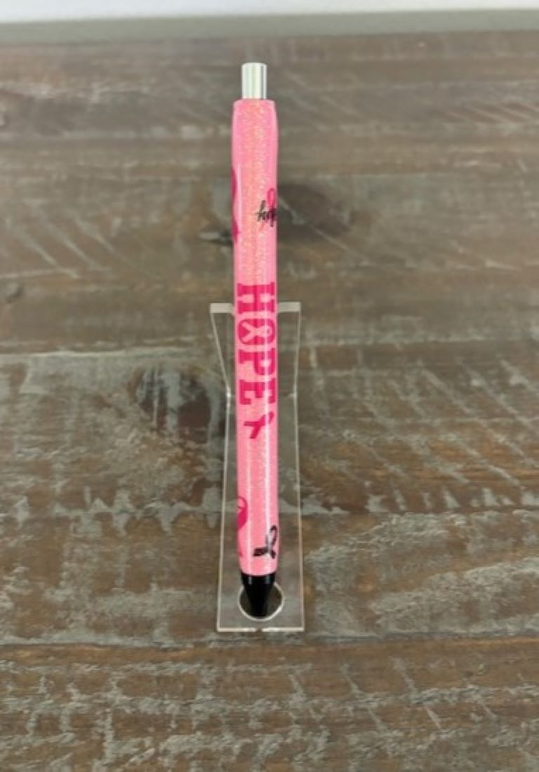 I made this pen in honor of all my friends and family that have fought breast cancer. I used pink and iridescent glitter and decorated it with hope and the iconic pink ribbon. I used two coats of resin to cover the stickers and glitter so that it feels nice and smooth. The pen is a gel pen and can be easily refilled by unscrewing the end. There is a red wax tip covering the end so that the gel doesn't leak out. That is easily removed with your fingernail.