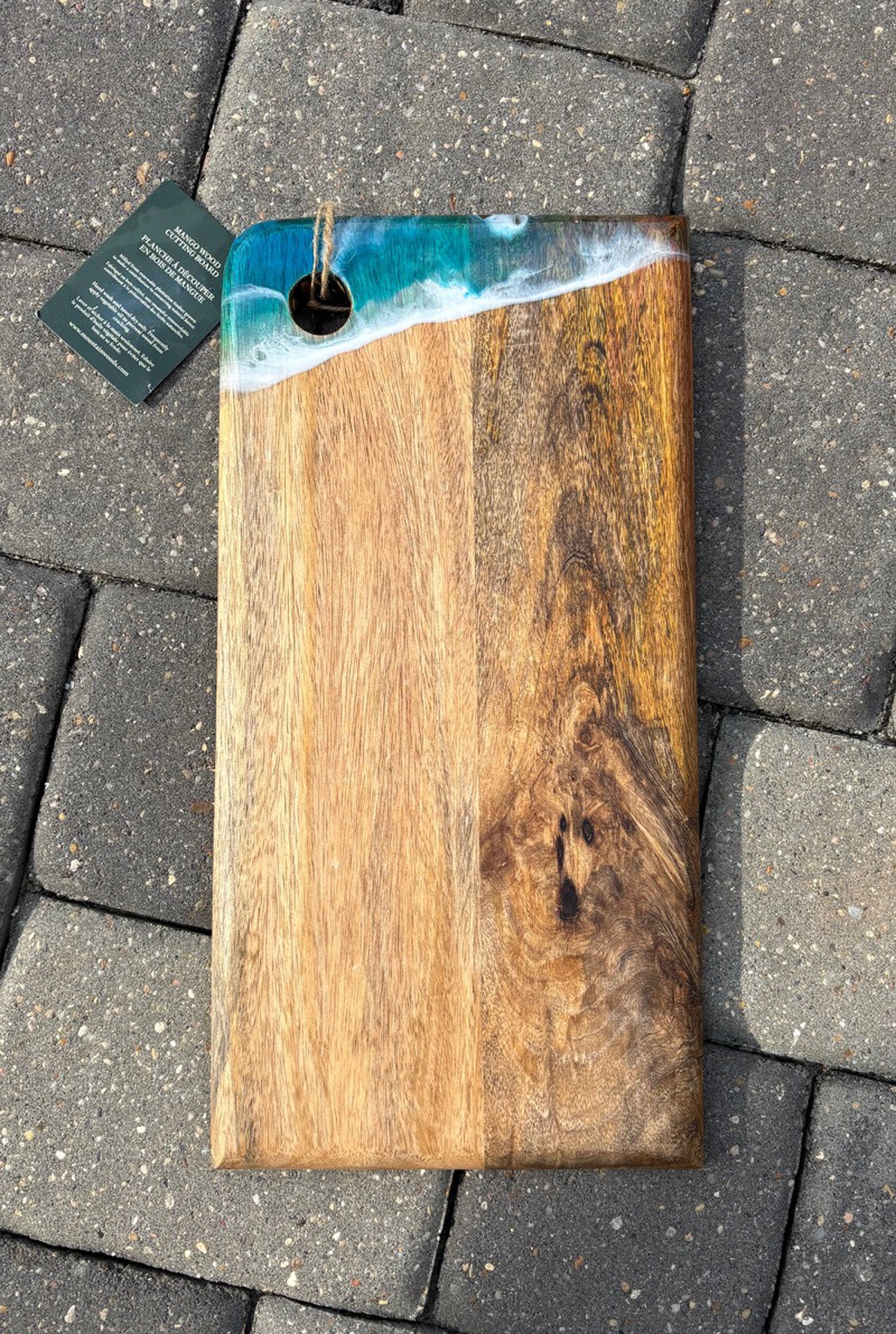 <p>This pretty board is lightweight for its size. The mango wood has beautiful grain.</p> <p>One corner has a subtle ocean scene with turquoise waters and white waves. There is plenty of room to place your charcuterie arrangement.</p> <p>Resin is UV Resistant and Food Safe.</p> <p>Approximate size: 16 x 8 inches</p>