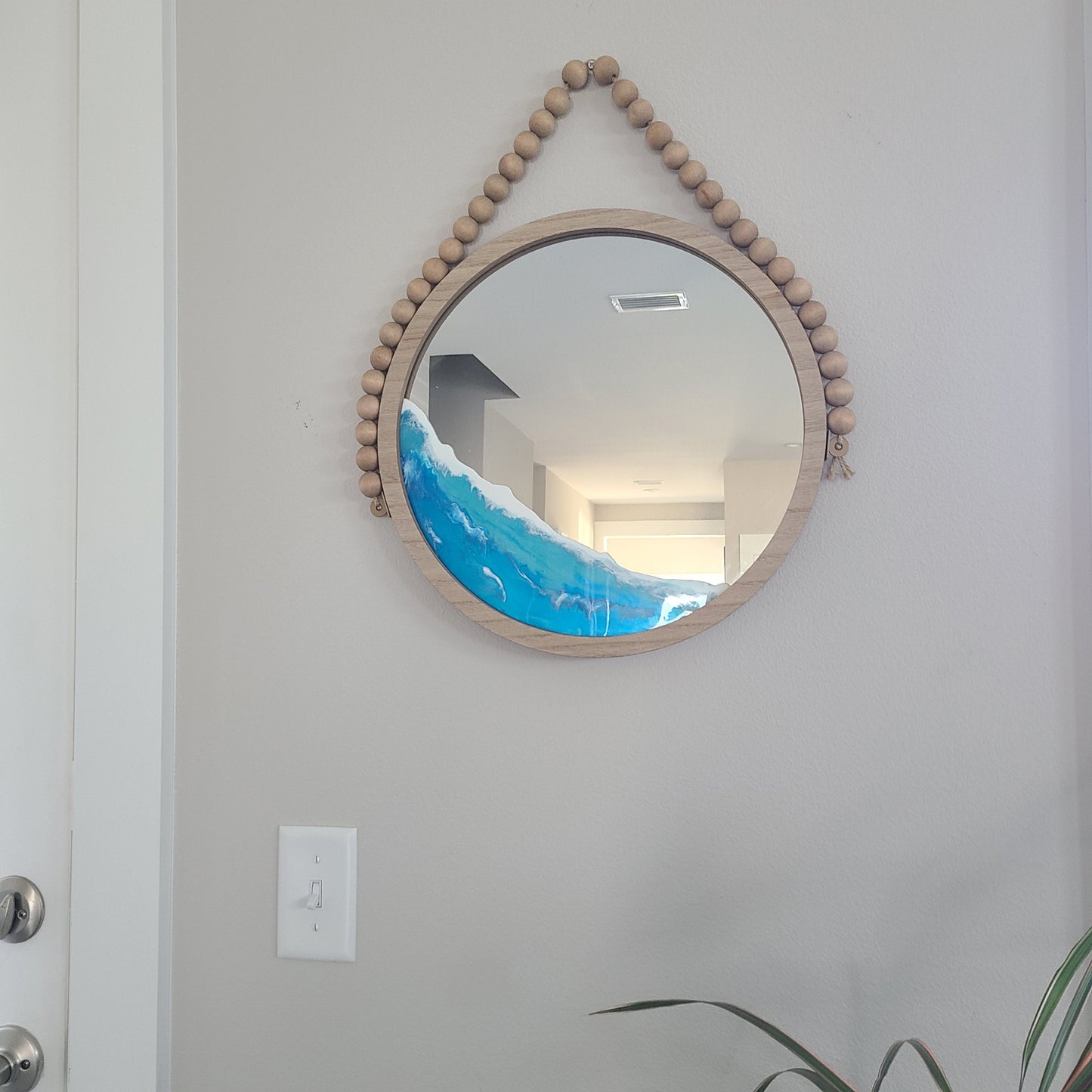 Round wood mirror with beads on rope for hanging. The mirror and the beads are made of wood. I did an ocean look offset from the center so that you can still look into it. Approximate size: 16 inches round