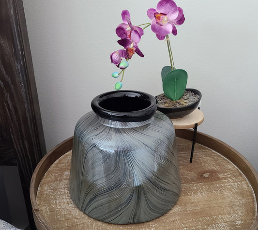 Black vase has silver metallic coating on the outside with lines that let the black show through. Lines resemble a feather. Has a reflective quality to it. Cyan Design. Heavy vase. Approximate size: 8 inches tall, 7.5 inches wide. Weighs 6.5 lbs.