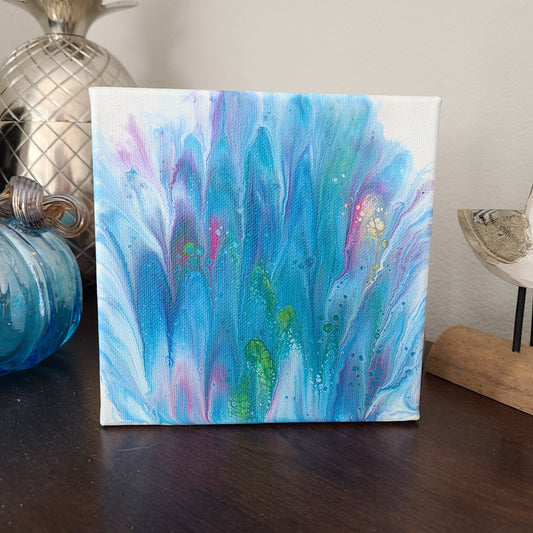 6x6 Canvas, Acrylic art. Fingers of blue, purple and pink with splashes of green and yellow make this abstract art look like Spring is blooming. Can sit on a shelf or hang on a wall.