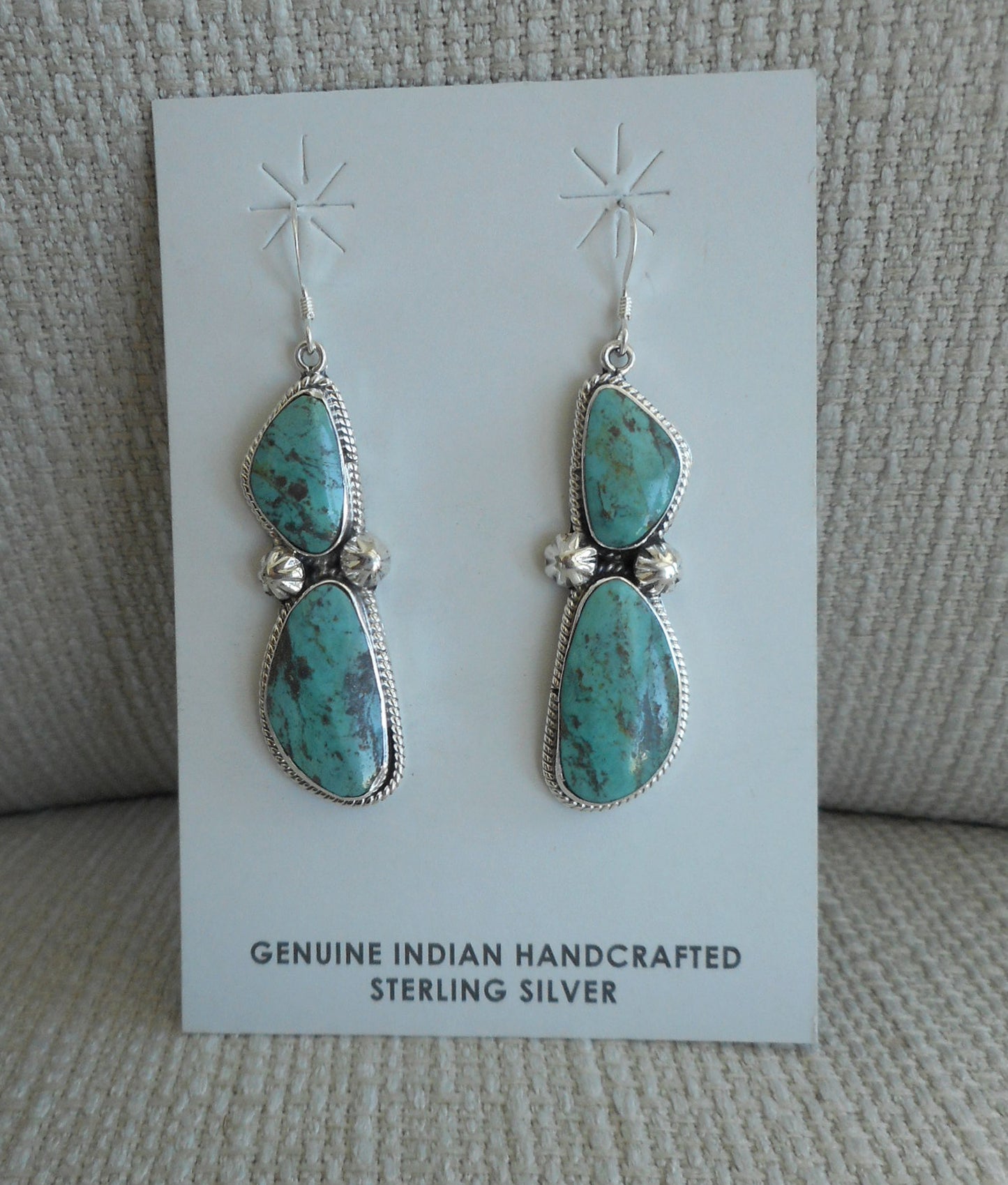 Navajo Sterling Silver earrings on French hooks. Each earring has 2 freeform stones that match each other really well. Each has twisted wire surrounding the bezel and two stamped beads. Overall length 2.5 inches.