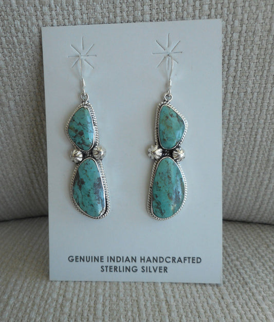 Navajo Sterling Silver earrings on French hooks. Each earring has 2 freeform stones that match each other really well. Each has twisted wire surrounding the bezel and two stamped beads. Overall length 2.5 inches.