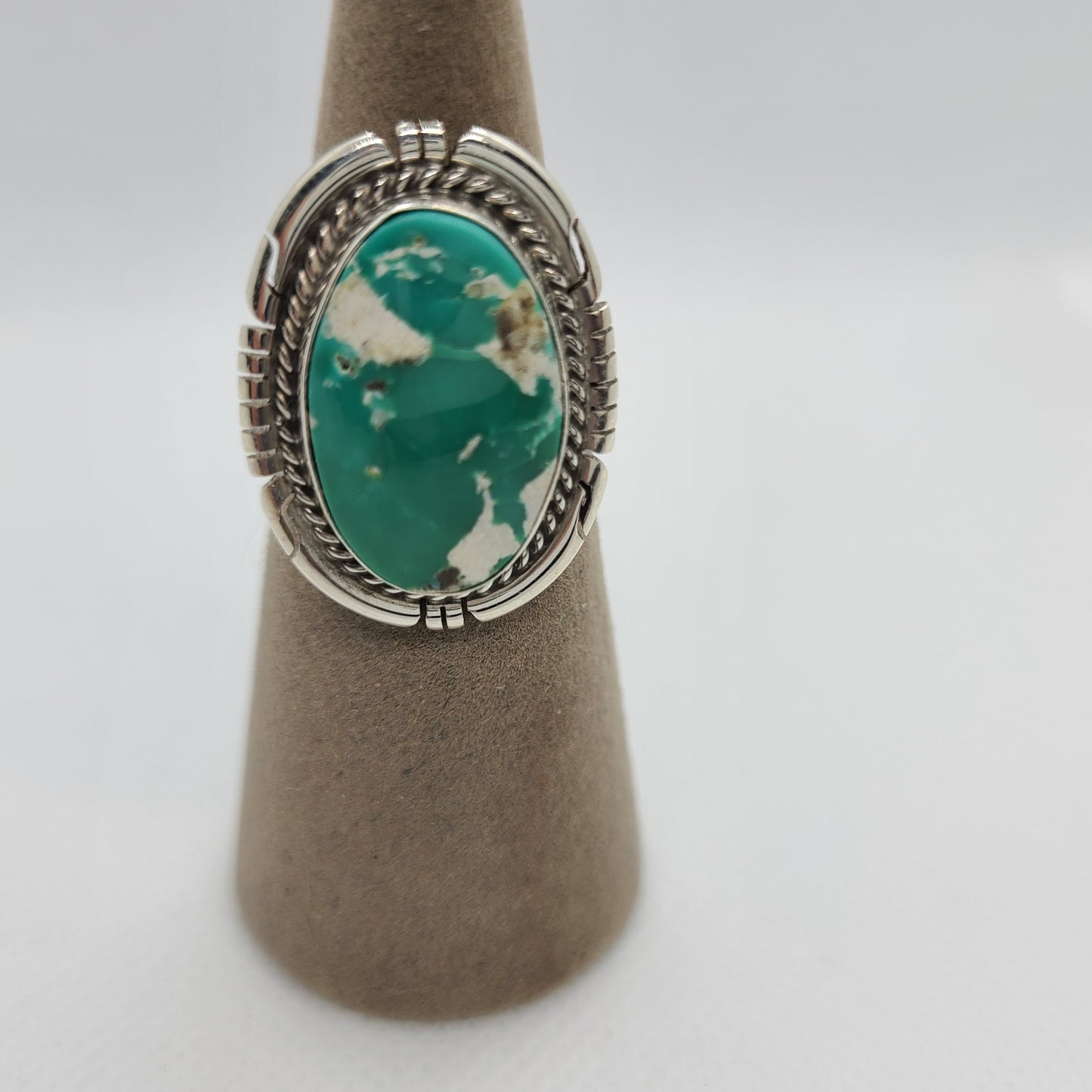 Green, white and brown oval Royston Turquoise stone. Large oval bezel set with saw-cut backplate and twisted wire around the stone. Size 7. Certificate of Authenticity included. Navajo artist, Dave Skeets. The ring is a little larger than a quarter.