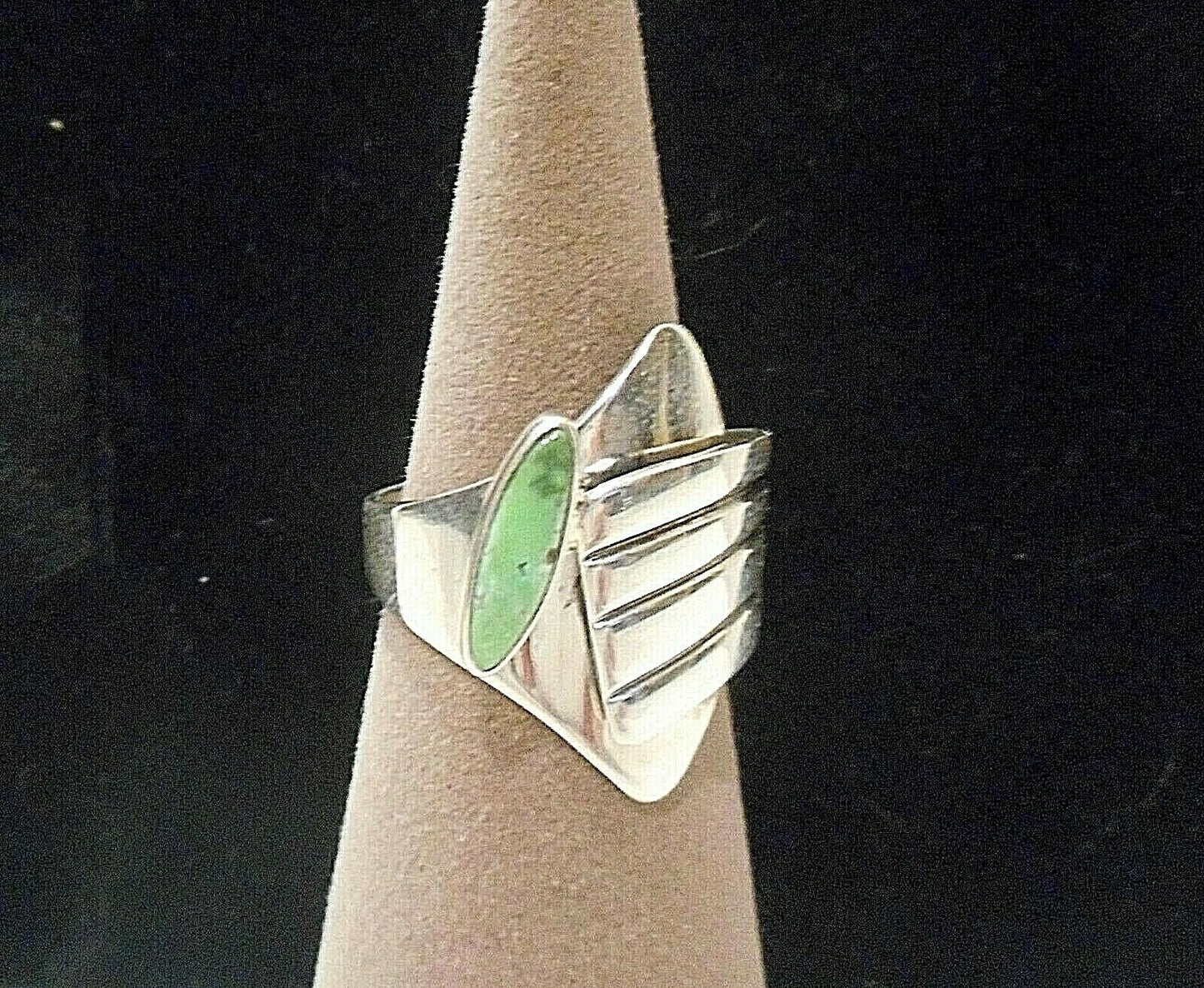 Green Oval turquoise stone from Carico Lake. Highly sought after and becoming rare. Ring is made of Sterling Silver and is adjustable. Measures at a size 7.5, but can go 1/2 size either smaller or larger. Made in the USA. Made by Juan Willie for Gertrude Zachary.