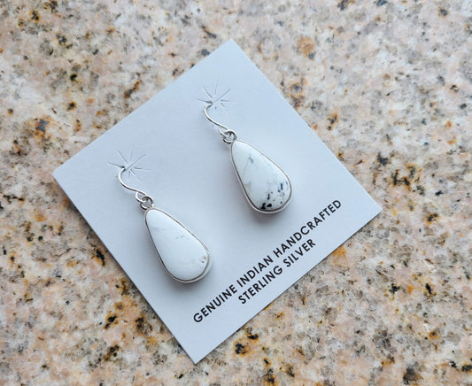 White Buffalo pear or teardrop shaped earrings set in a simple Sterling Silver plain bezel. This White Buffalo is mostly white with a small amount of black matrix. On simple Sterling French Hooks. Navajo Artist, Shirley Henry. Approximately 1.25 inches long.
