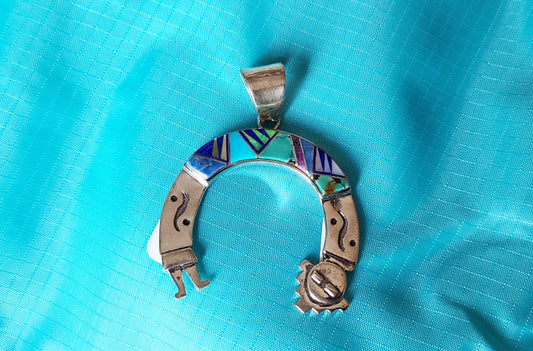 Yei or Kachina is curved into a U shape. Made of Sterling Silver and inlaid stones. The stones cover the top third of the piece. Beautiful blue and green turquoise, lapis and Mother of Pearl stones. Measures approximately 2.5 x 1.75 inches