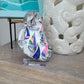 This bright and cheery oyster shell has a sailboat regatta theme.  Use as a trinket dish or on the stand to accent any small area.  Large Real Oyster Shell is Painted Metallic Silver on the edges and back.  Finished with three coats of UV Protective spray varnish.  Clear Acrylic Stand Included  Approximate size: 5.5 x 3.75 inches at the widest part  Accessories shown are NOT included.