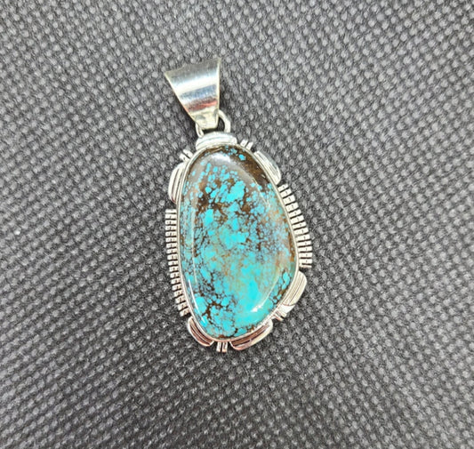 New with tags! Beautiful Bisbee Turquoise pendant by Navajo Artist, Larry M. Yazzie. Bisbee Turquoise is very rare and comes from the Bisbee Mine in Arizona which was closed in 1975.  There is very little Bisbee Turquoise available today and due to it's rarity and exceptional beauty it is very valuable. The stone is set in a Sterling Silver bezel with saw cuts.  The bail is large enough to accommodate most any chain or leather. MSRP: $500  Item will be shipped insured and a Signature will be required.