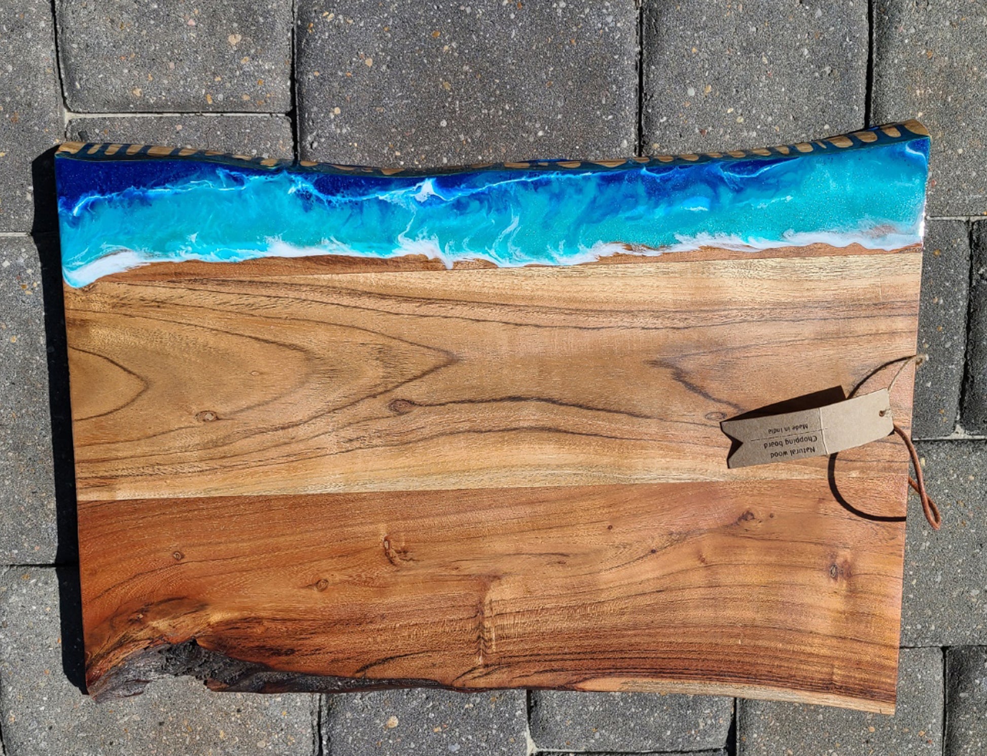 The wild, wild waves created in resin on this beautiful cutting board.  This cutting board is thick and heavy.  Beautiful live edge on one edge.    Resin ocean and waves are UV resistant and food safe.  Care: Resin can be cleaned with an alcohol wipe or a damp cloth.  The wood should be occasionally treated with Food Grade Mineral Oil or Olive Oil.  Weighs approximately 8.5 pounds!  Local pickup is available.