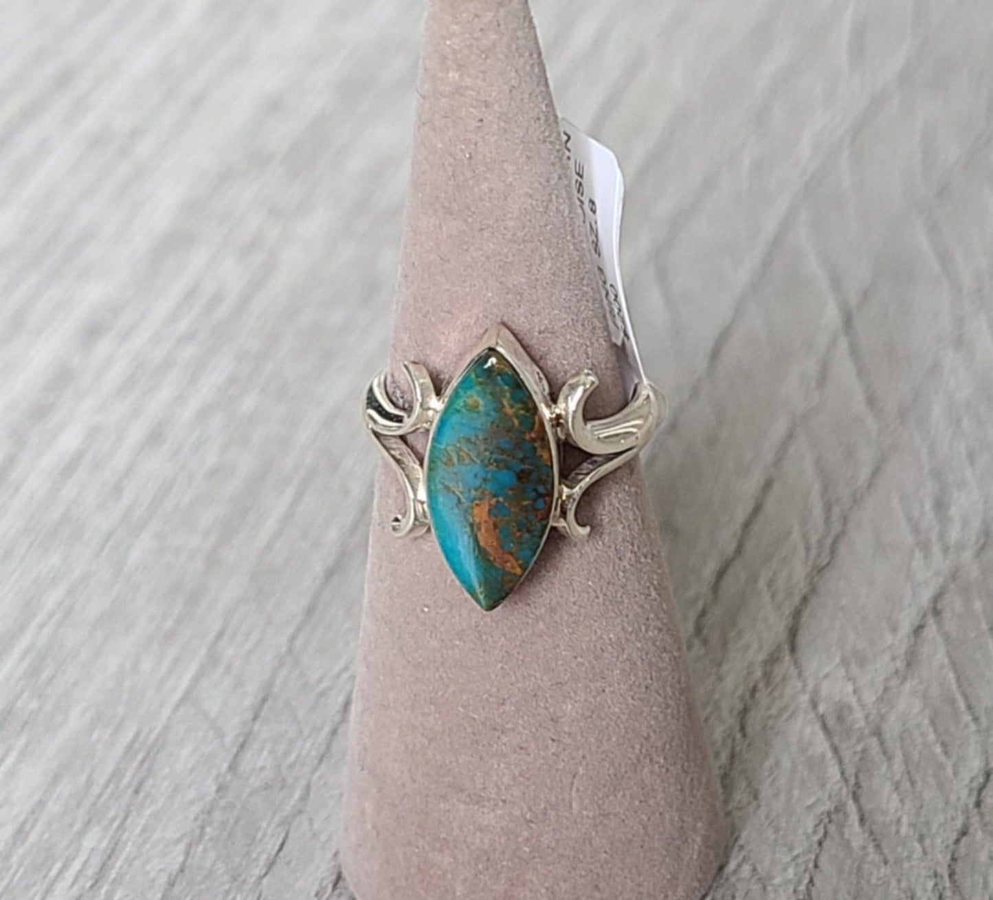 New! Beautiful color in this Kingman Turquoise. The stone is an elongated elliptical shape with pointed ends or "Marquise". Kingman turquoise comes from Arizona Bezel set with a split band and curved accents. Ring is size 8 Navajo artist, Larry Castilo Comes with Certificate of Authenticity as shown. MSRP: $200