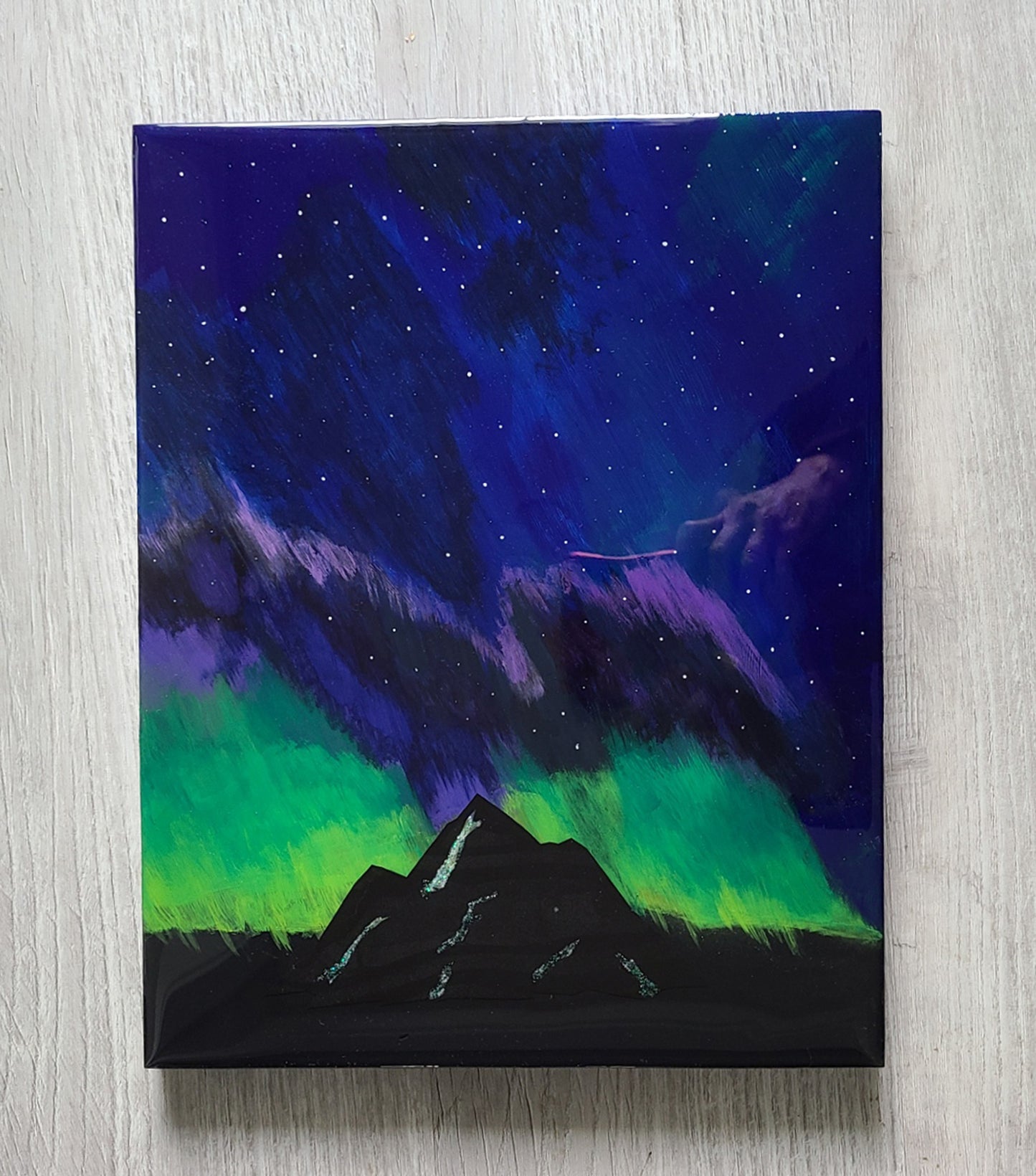 It's a bright and starry night!  The colorful Northern Lights play over the mountains in the foreground.  The mountain sparkles with snow in the crevices.  Original Artwork  Resin is UV Resistant.  Done on wood, but lightweight.  Approximate size: 11 x 14 x 1 inches  If you would like it signed on the back, leave a message with your order.