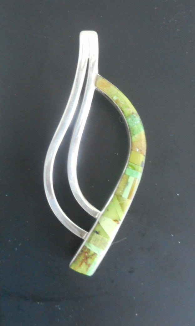 Unique contemporary pendant. 2 waves of silver curve down to meet a curve of inlay Orvil Jack Turquoise.  The turquoise is various shades of lime green and is inlaid.  Approximate 3 inches long.