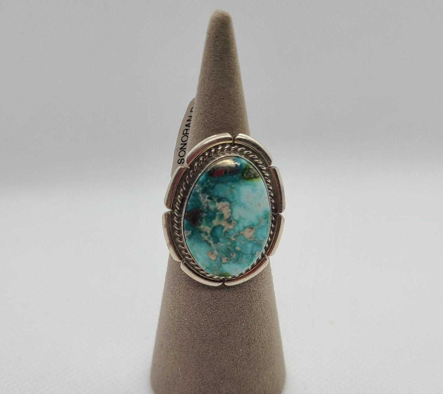 Beautiful stone in this Sonoran Rose Turquoise Ring Set in Sterling Silver Size 6 Split Band Twisted Rope around the bezel and saw cuts on the backplate. Navajo Artist, Dave Skeets This Turquoise is mined in Mexico near the city of Cananea. This material is relatively new to the industry and is a newer deposit in the Cananea mines. MSRP: $200