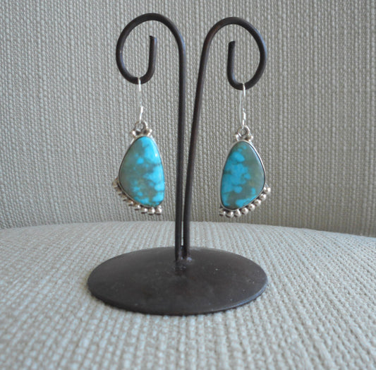 Kingman Turquoise dangle earrings. Beautiful shades of blue in the stunning earrings.  Set in Sterling Silver with beads of silver accent on the top and bottom of these freeform stone earrings.  Artist Sharon McCarthy. Approximately 1.5 inches long.  Native American. Comes with Certificate of Authenticity.