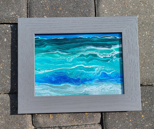I created this lively, vivid ocean at my home in Florida after a storm came through and the ocean was active. The painting is made with Acrylic paints in shades of blue, green, white and gray. The painting is 5 x 7, but with the frame, it is 9x7. The frame is gray. Can hang on the wall or stand alone. It is signed on the back, but you can't see it unless you take it out of the frame.